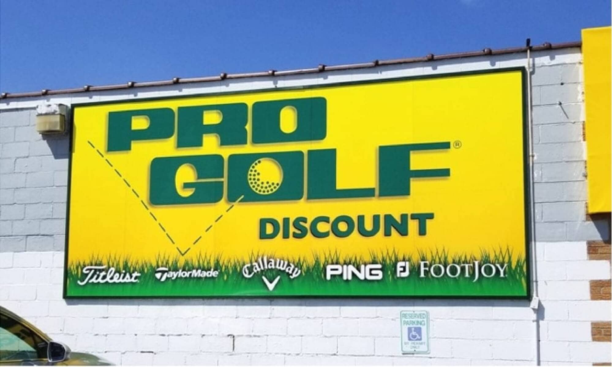 Pro Golf Discountの看板。タイトリスト、テーラーメイド、キャロウェイ、PING、フットジョイなど主要ゴルフブランドのロゴが並ぶ。